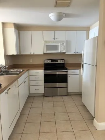 a kitchen with cabinets and steel stainless steel appliances