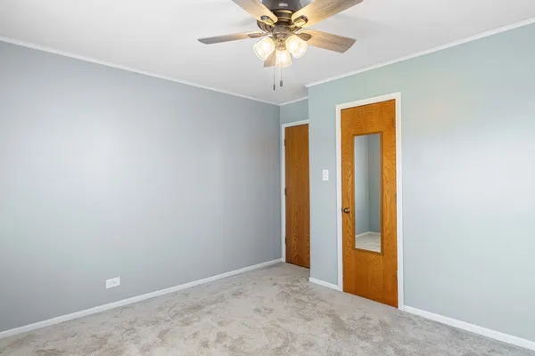 an empty room with a chandelier fan and a chandelier fan