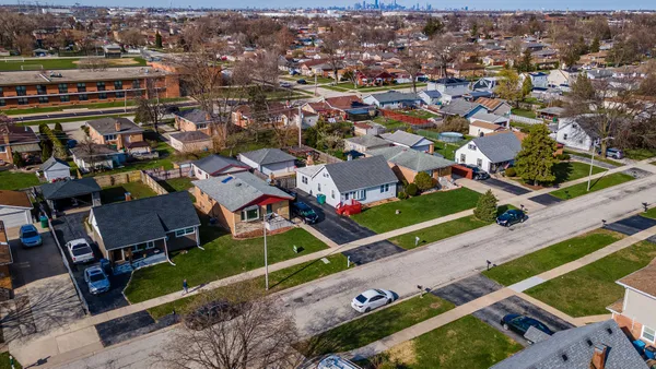 a aerial view of a house with a yard table and chairs