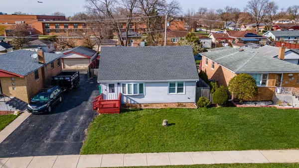 a aerial view of a house with a yard table and chairs