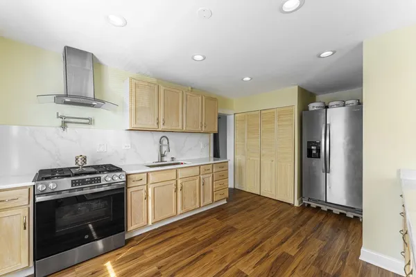 a kitchen with stainless steel appliances granite countertop a stove a sink and a refrigerator