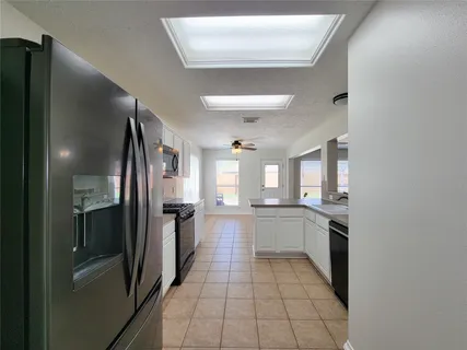 a large kitchen with a stove and a refrigerator