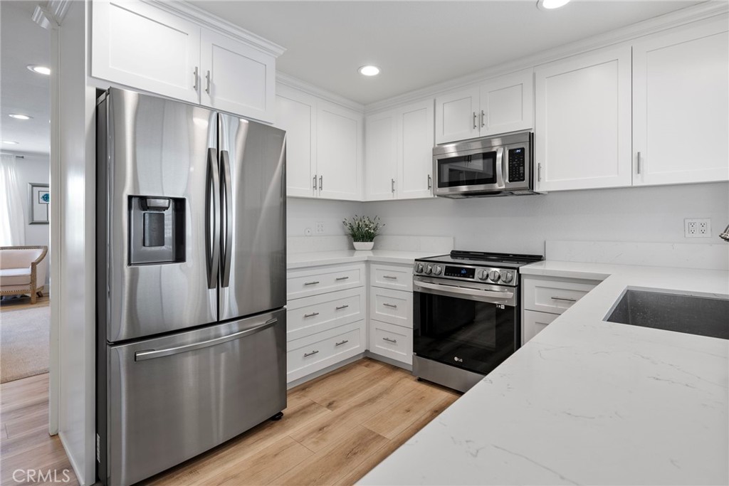 22287 Modina Laguna Hills, CA 92653 - Photo 11 of 25 a kitchen with stainless steel appliances white cabinets and a refrigerator
