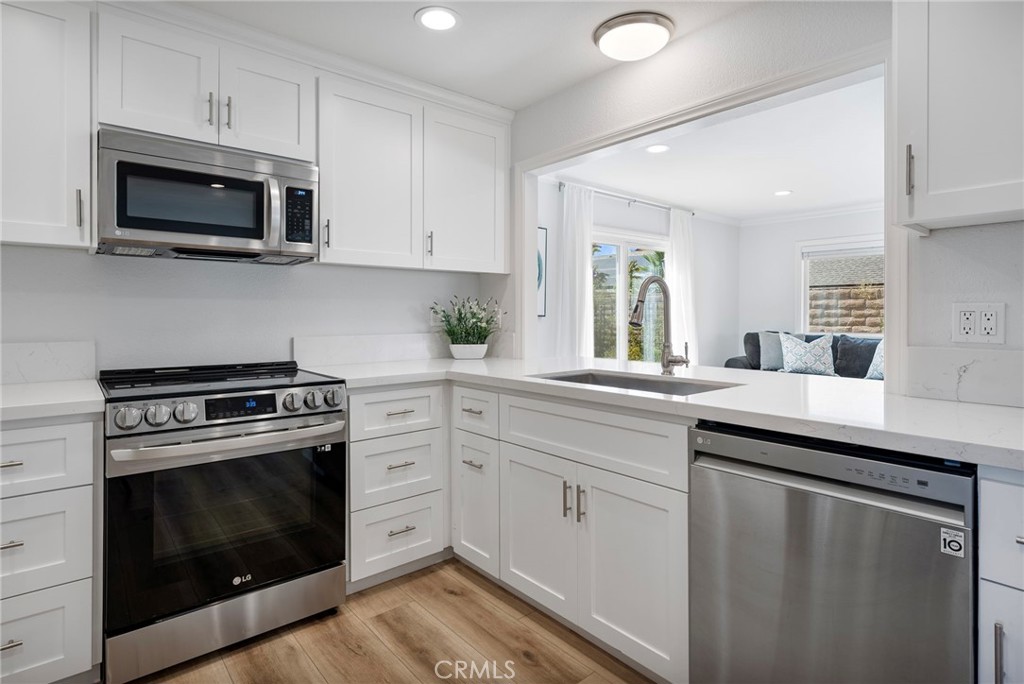 22287 Modina Laguna Hills, CA 92653 - Photo 12 of 25 a kitchen with white cabinets stainless steel appliances and sink