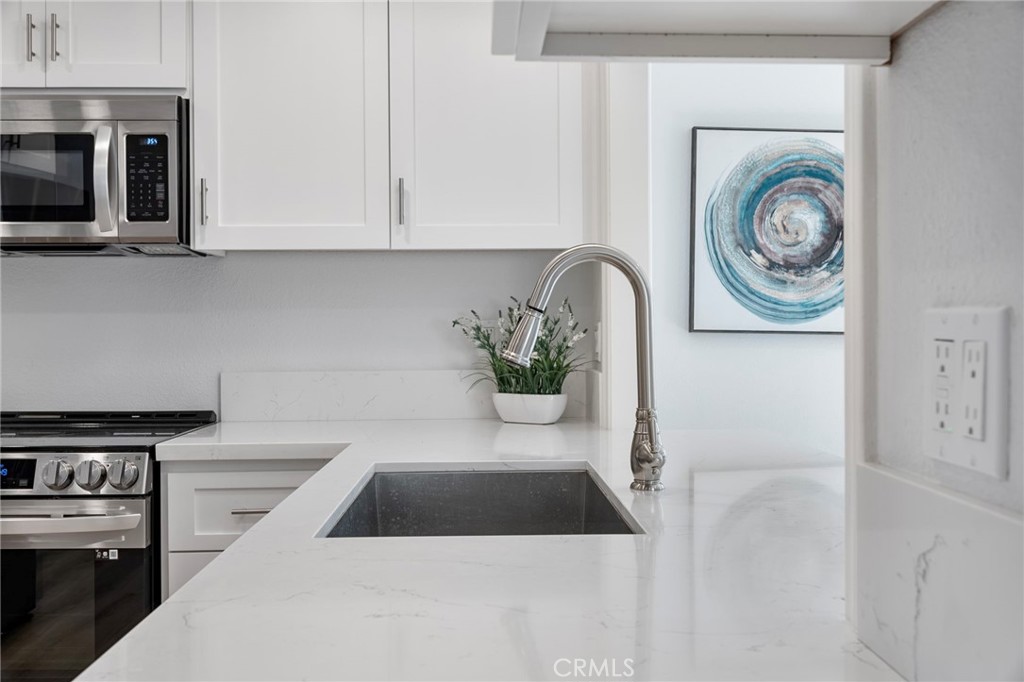 22287 Modina Laguna Hills, CA 92653 - Photo 13 of 25 a kitchen with cabinets and window