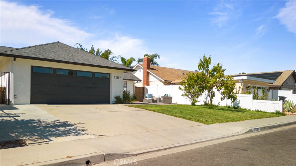 22287 Modina Laguna Hills, CA 92653 - Photo 2 of 25 a front view of a house with a yard and garage