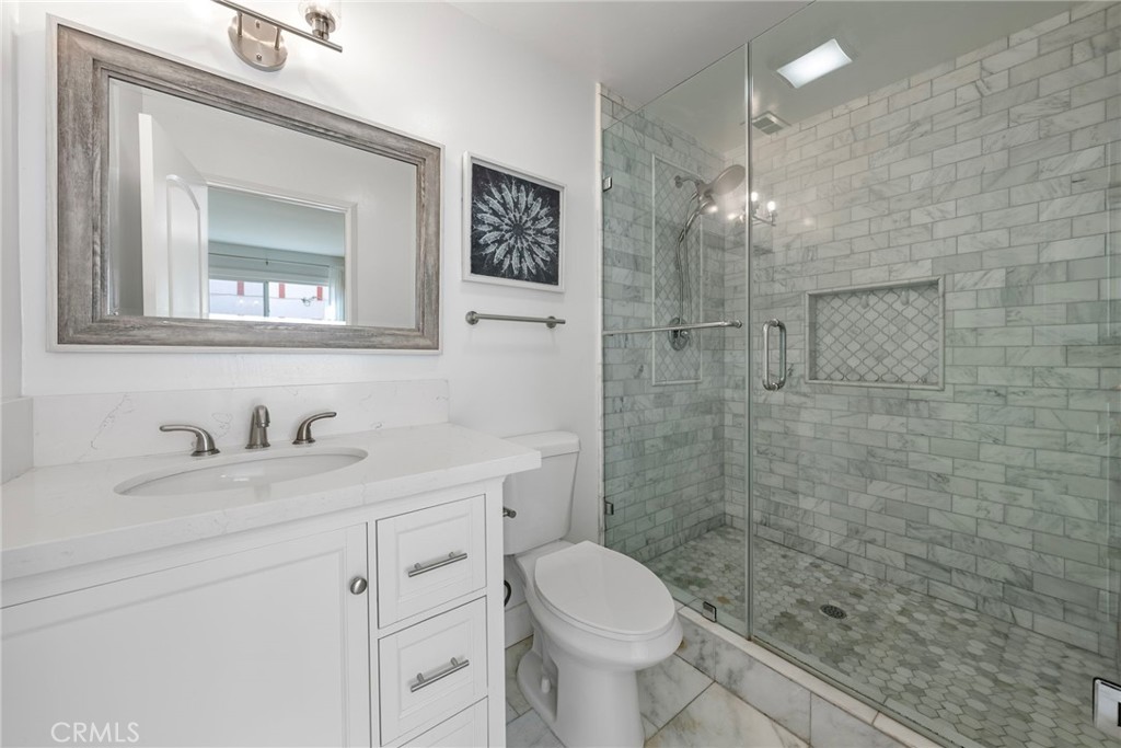 22287 Modina Laguna Hills, CA 92653 - Photo 23 of 25 a bathroom with a granite countertop sink a toilet and a mirror