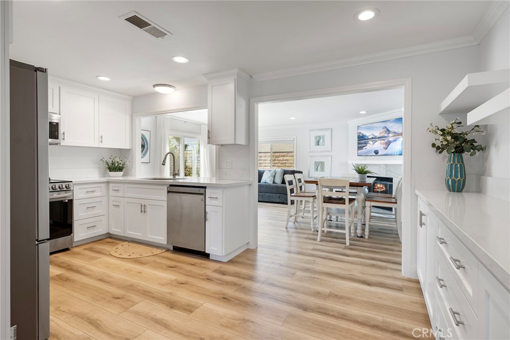 22287 Modina Laguna Hills, CA 92653 - Photo 8 of 25 a kitchen with white cabinets and counter space