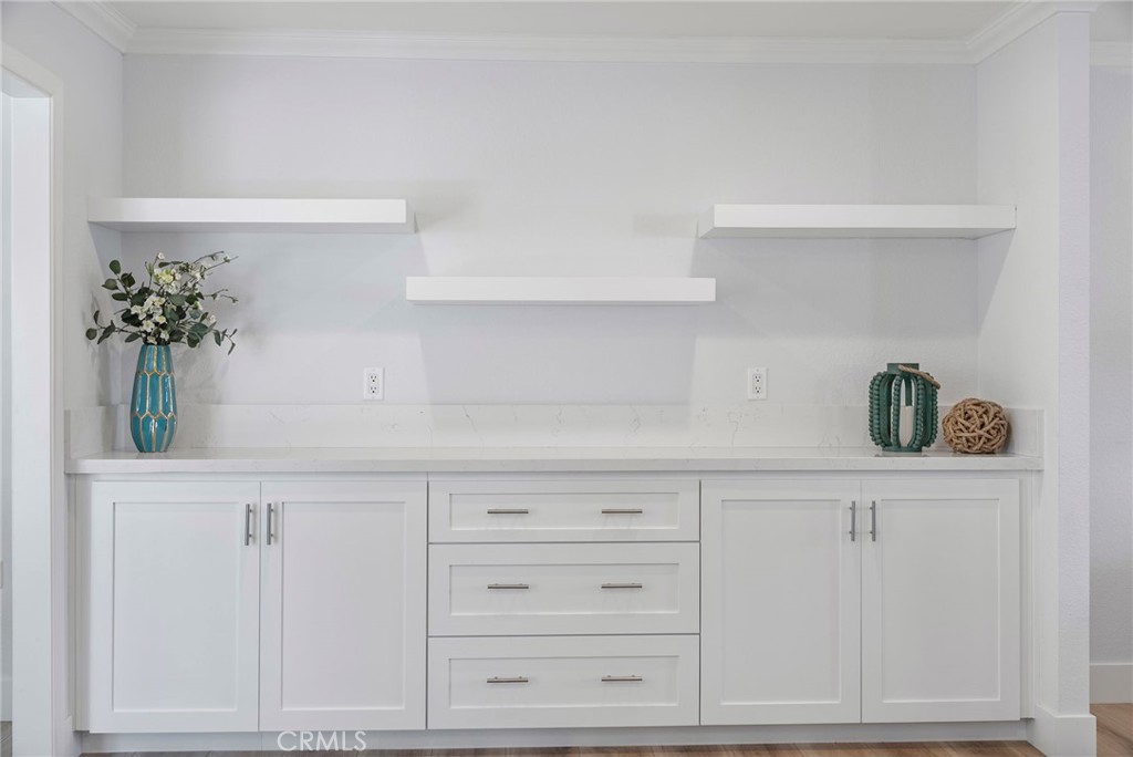 22287 Modina Laguna Hills, CA 92653 - Photo 9 of 25 a kitchen with white cabinets and potted plant