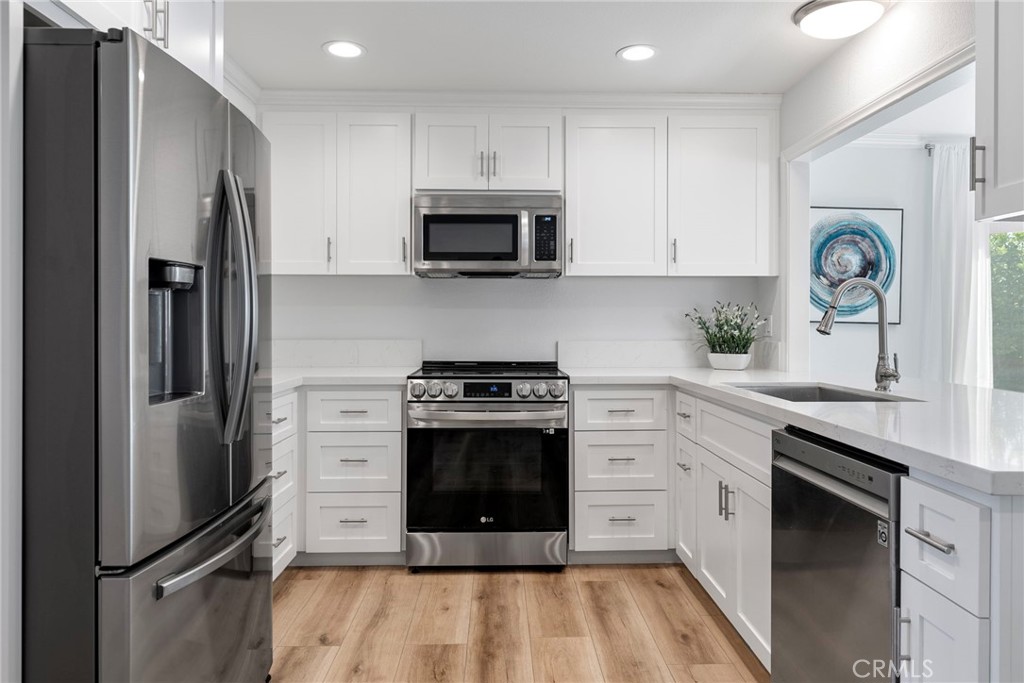 22287 Modina Laguna Hills, CA 92653 - Photo 10 of 25 a kitchen with stainless steel appliances a refrigerator stove and white cabinets