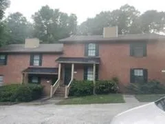 a front view of a house with a garden and plants