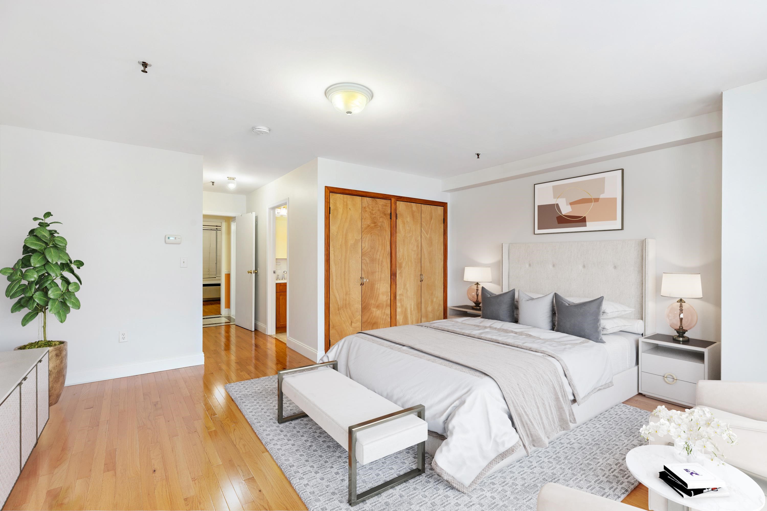 56 Ferguson Street, Unit C2 Newark, NJ 07105 - Photo 15 of 16 a spacious bedroom with a large bed and a potted plant