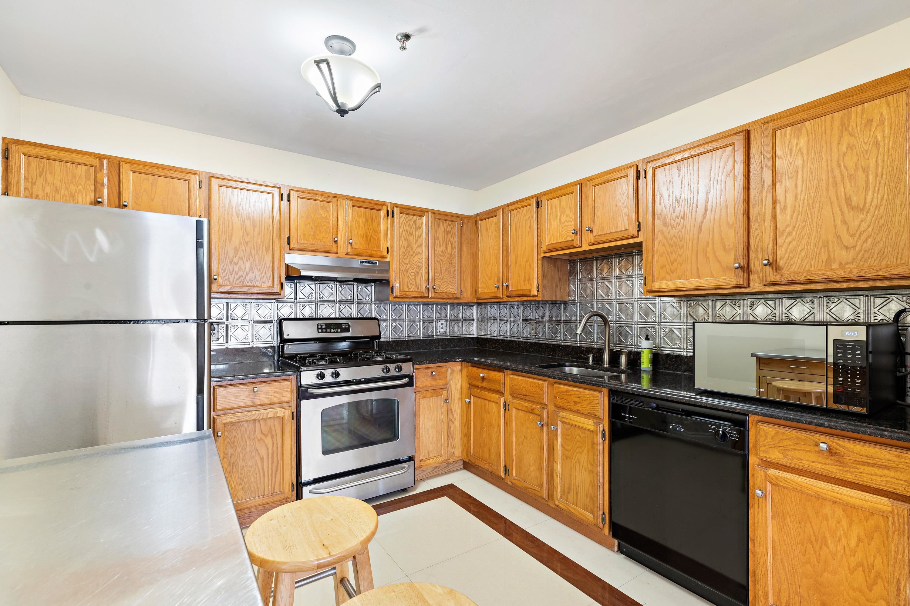 56 Ferguson Street, Unit C2 Newark, NJ 07105 - Photo 4 of 16 a kitchen with stainless steel appliances granite countertop a stove a sink and a refrigerator