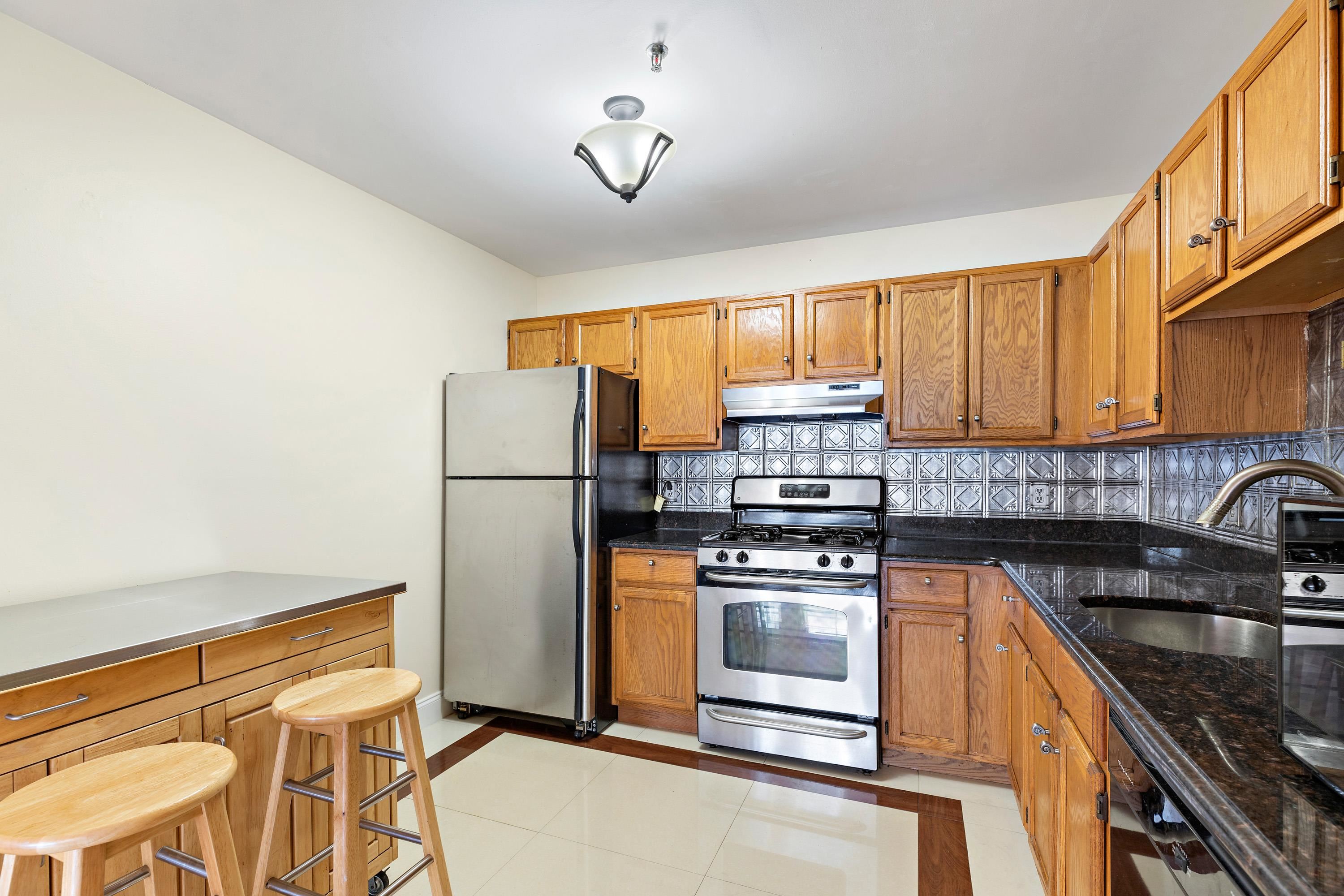 56 Ferguson Street, Unit C2 Newark, NJ 07105 - Photo 5 of 16 a kitchen with stainless steel appliances granite countertop a refrigerator stove sink and cabinets