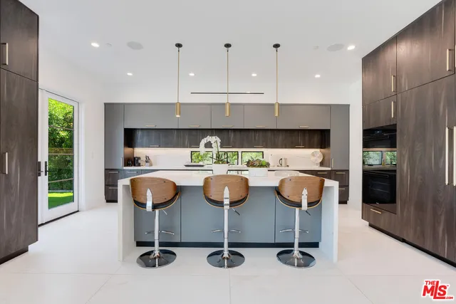 a kitchen with a dining table chairs and window