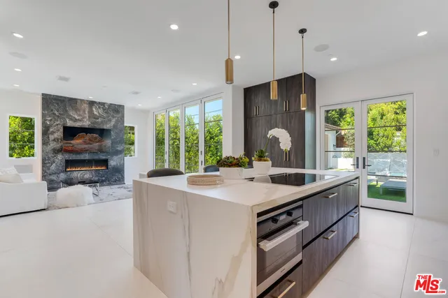 a kitchen with kitchen island a sink stove and refrigerator