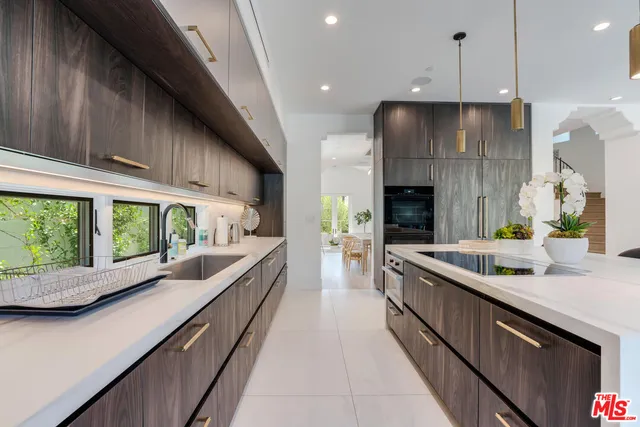 a open kitchen with stainless steel appliances granite countertop a lot of counter space and a large window