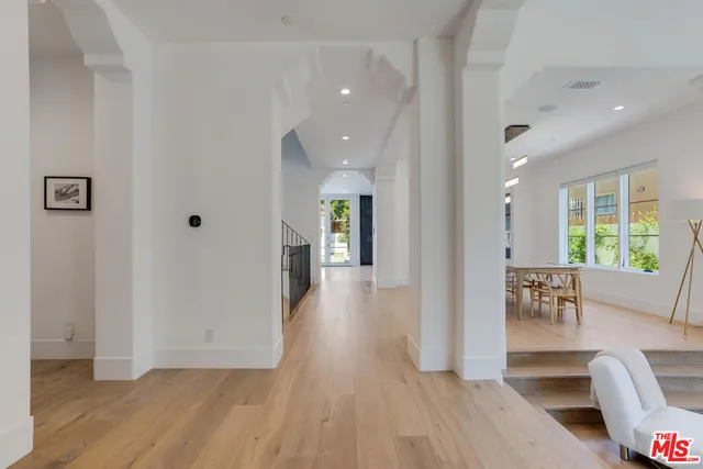 a view of a hallway with wooden floor and windows