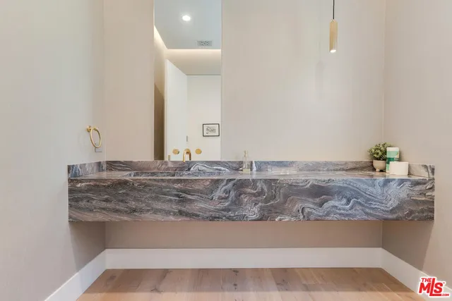 a bathroom with a granite countertop sink and a mirror