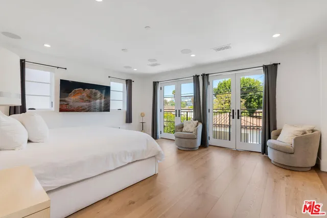 a spacious bedroom with a large bed and a large window