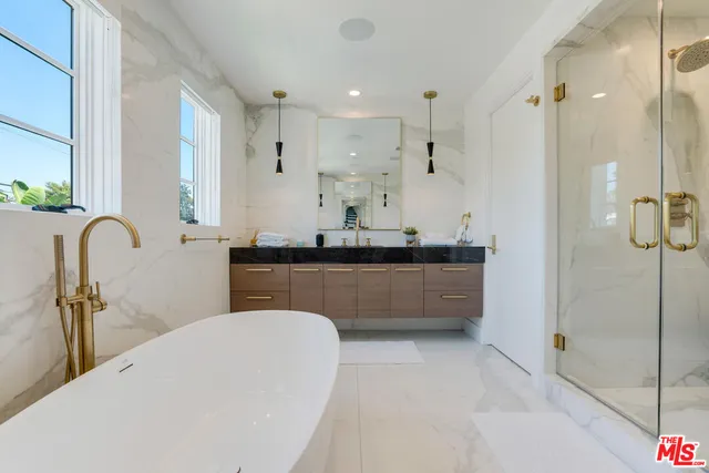 a large bathroom with a tub sink shower and mirror