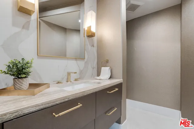 a bathroom with a granite countertop sink and a mirror