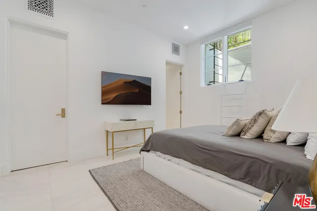 a bedroom with a bed and flat screen tv