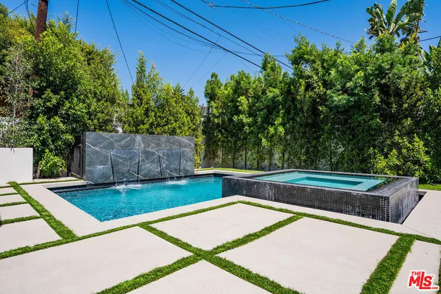 a view of a backyard with swimming pool in the back