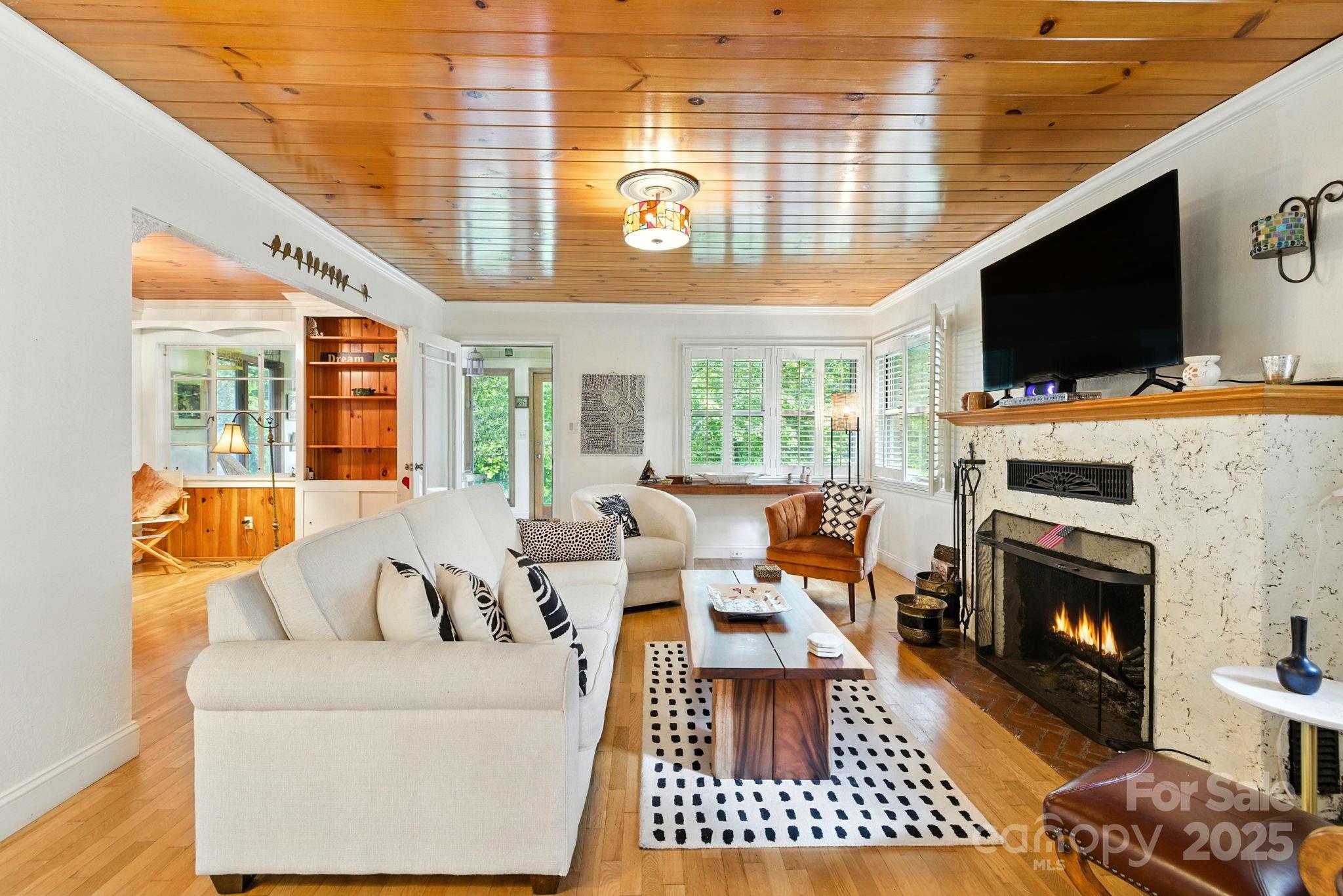 7741 Brevard Road Etowah, NC 28729 - Photo 14 of 48 a living room with furniture a flat screen tv and a fireplace