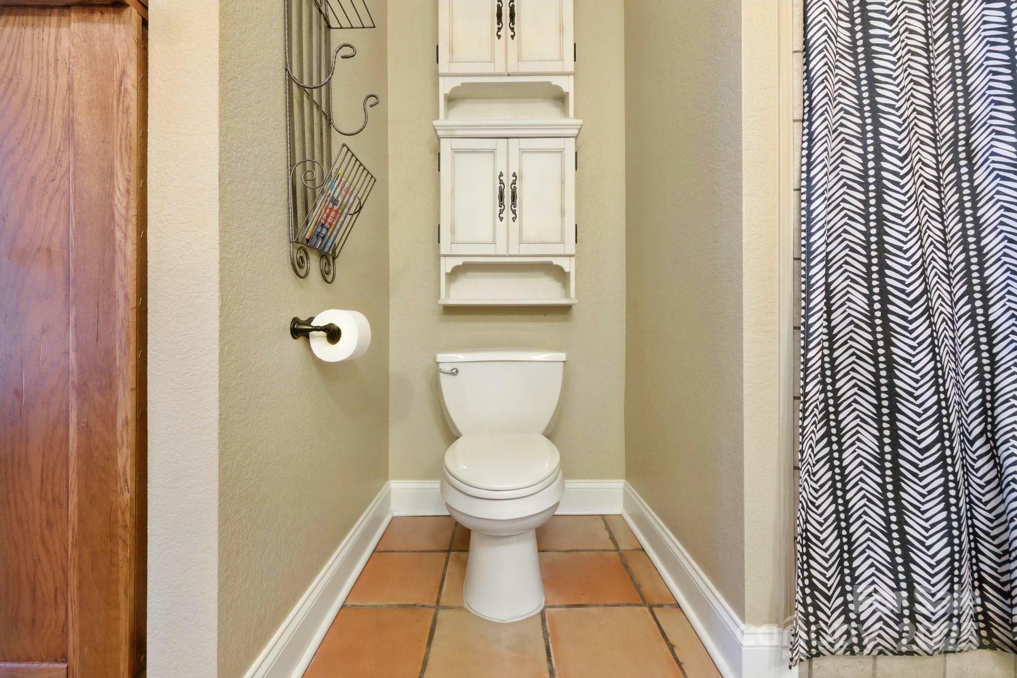 7741 Brevard Road Etowah, NC 28729 - Photo 25 of 48 a bathroom with a toilet and a shower curtain