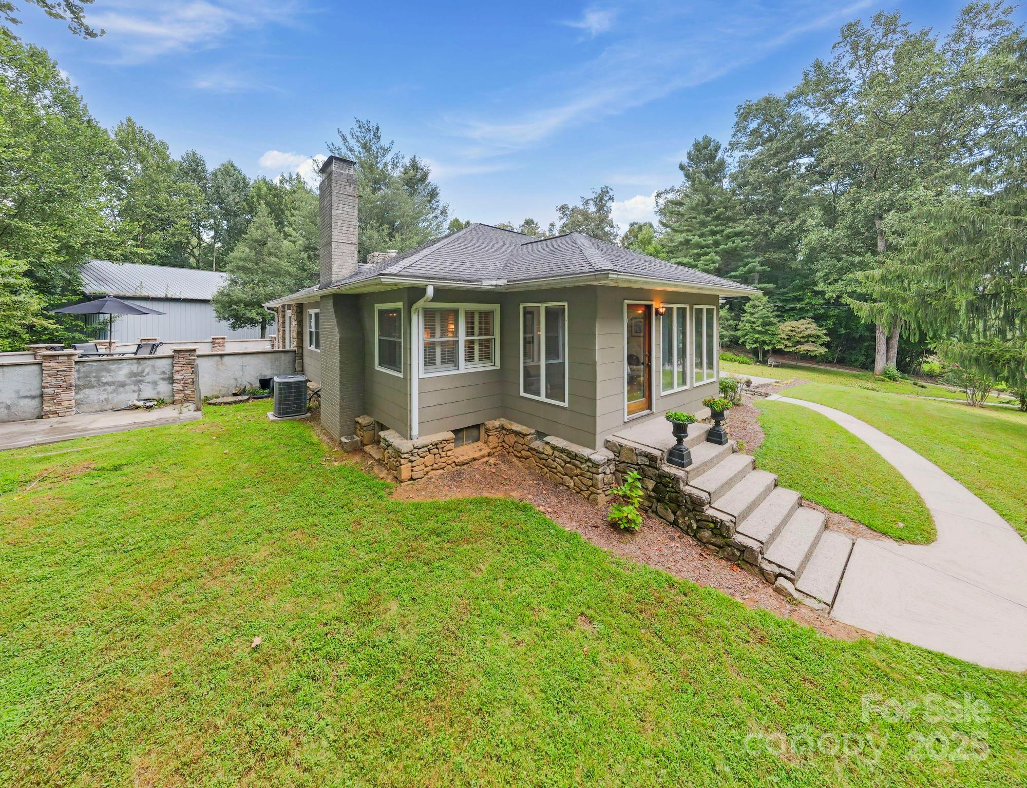 7741 Brevard Road Etowah, NC 28729 - Photo 3 of 48 a view of a house with a yard patio and a small yard