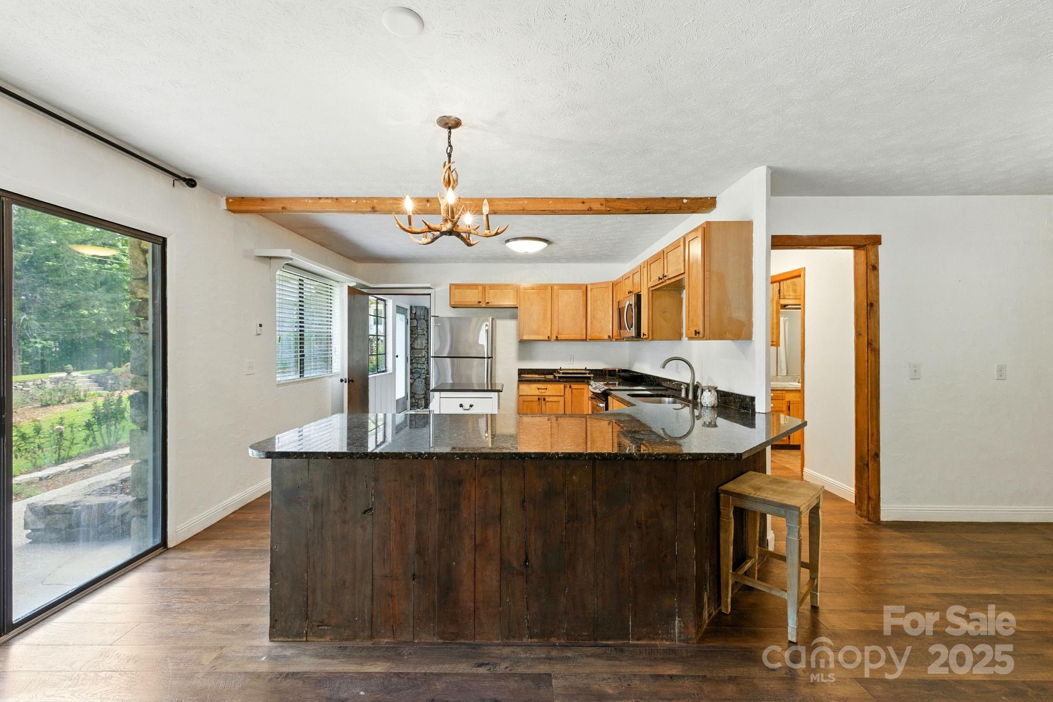 7741 Brevard Road Etowah, NC 28729 - Photo 41 of 48 a view of a kitchen with kitchen island stainless steel appliances a sink and living room view