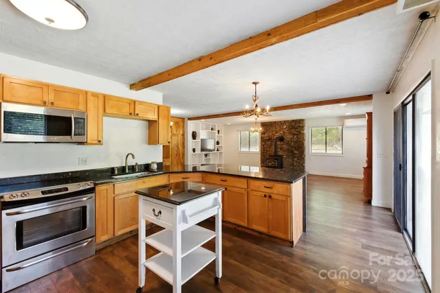 a kitchen with stainless steel appliances a refrigerator a stove a sink and a microwave