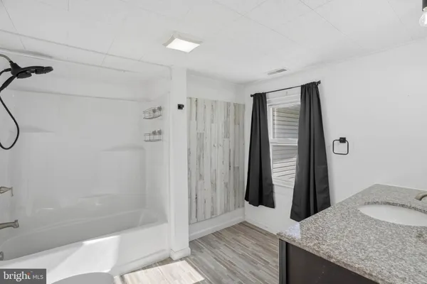 a bathroom with a granite countertop sink and shower
