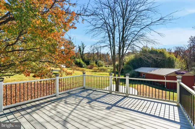 a view of balcony with wooden floor and fence and trees