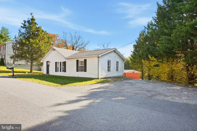 a view of house with swimming pool and yard