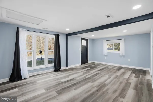 a view of a room with wooden floor and windows