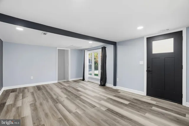 a view of an empty room with window and closet area