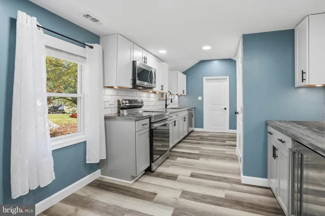 a kitchen with stainless steel appliances granite countertop a stove a sink and a refrigerator