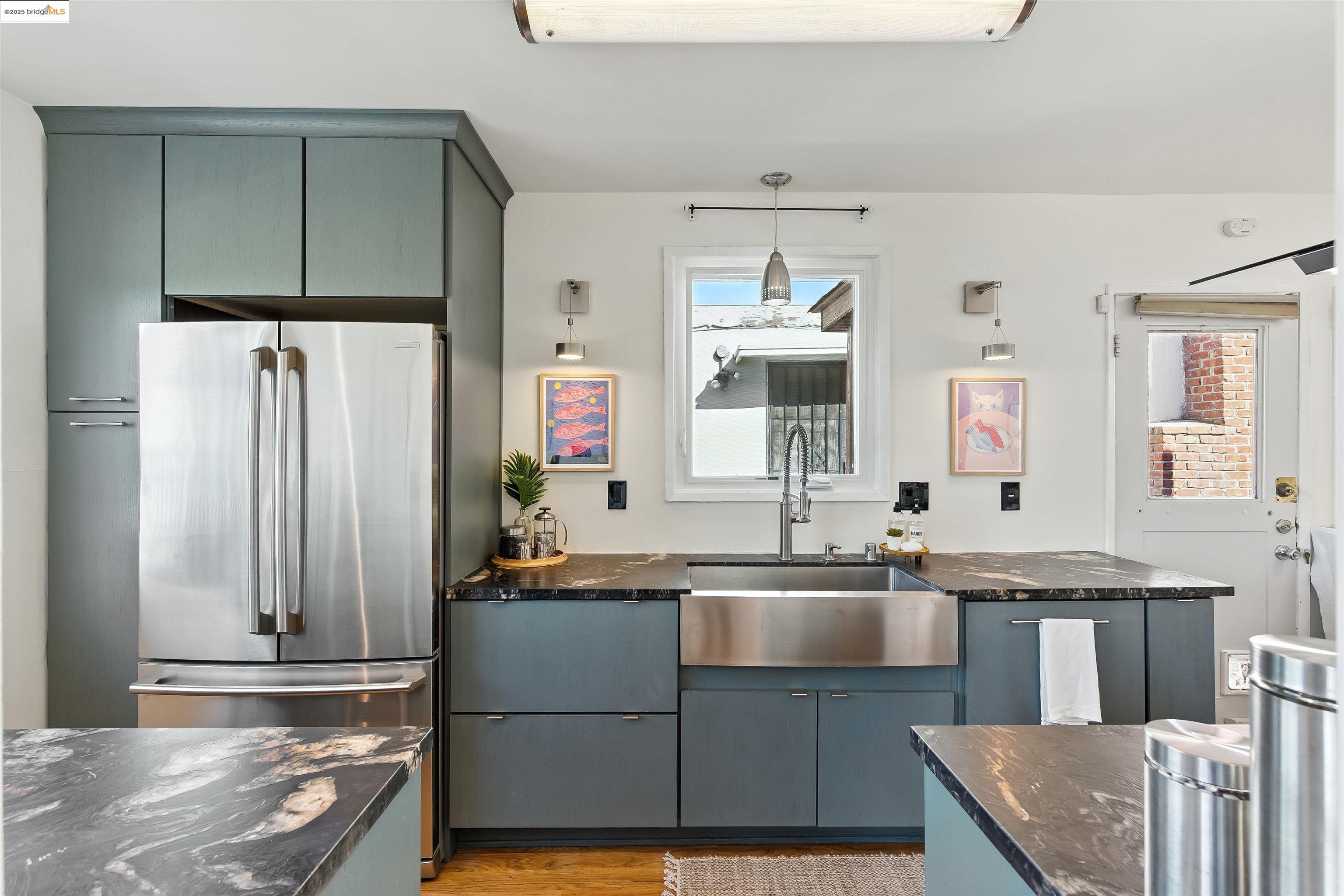 6623 Outlook Avenue Oakland, CA 94605 - Photo 11 of 38 Kitchen with freestanding refrigerator, pendant lighting, light wood-type flooring, blue cabinetry, and dark stone countertops