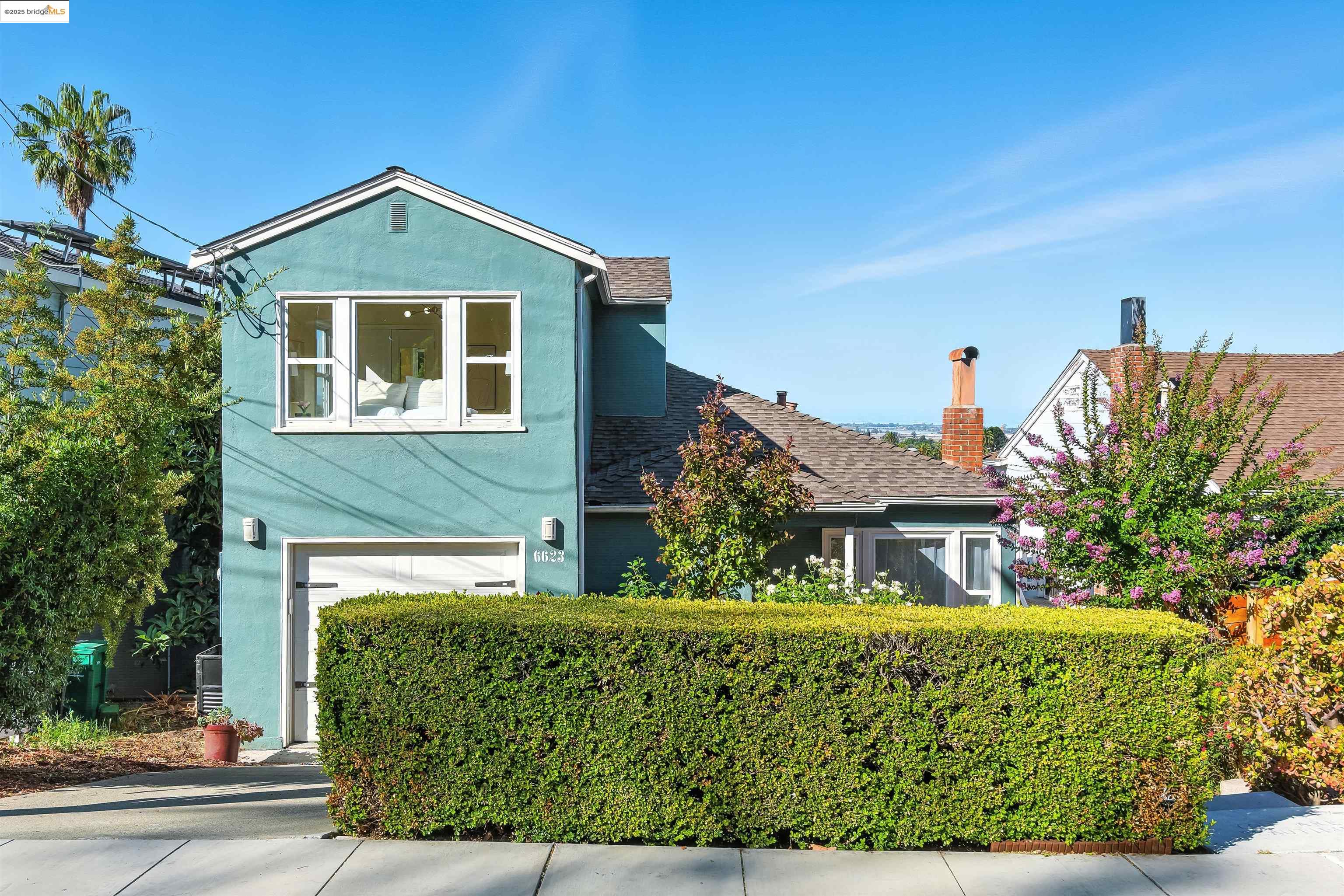 6623 Outlook Avenue Oakland, CA 94605 - Photo 2 of 38 Traditional-style house featuring stucco siding, an attached garage, a shingled roof, and concrete driveway