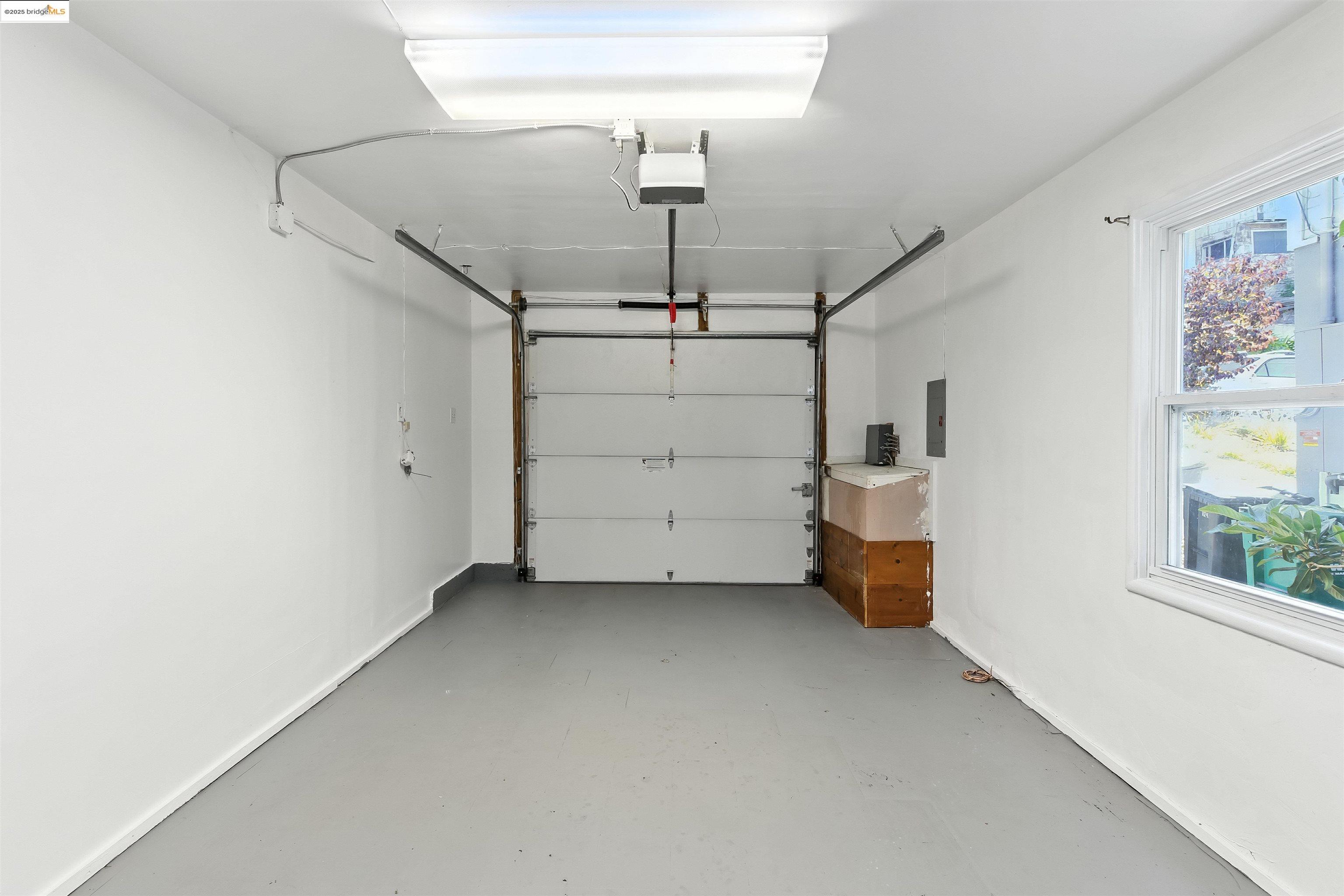 6623 Outlook Avenue Oakland, CA 94605 - Photo 23 of 38 Garage featuring a garage door opener and electric panel