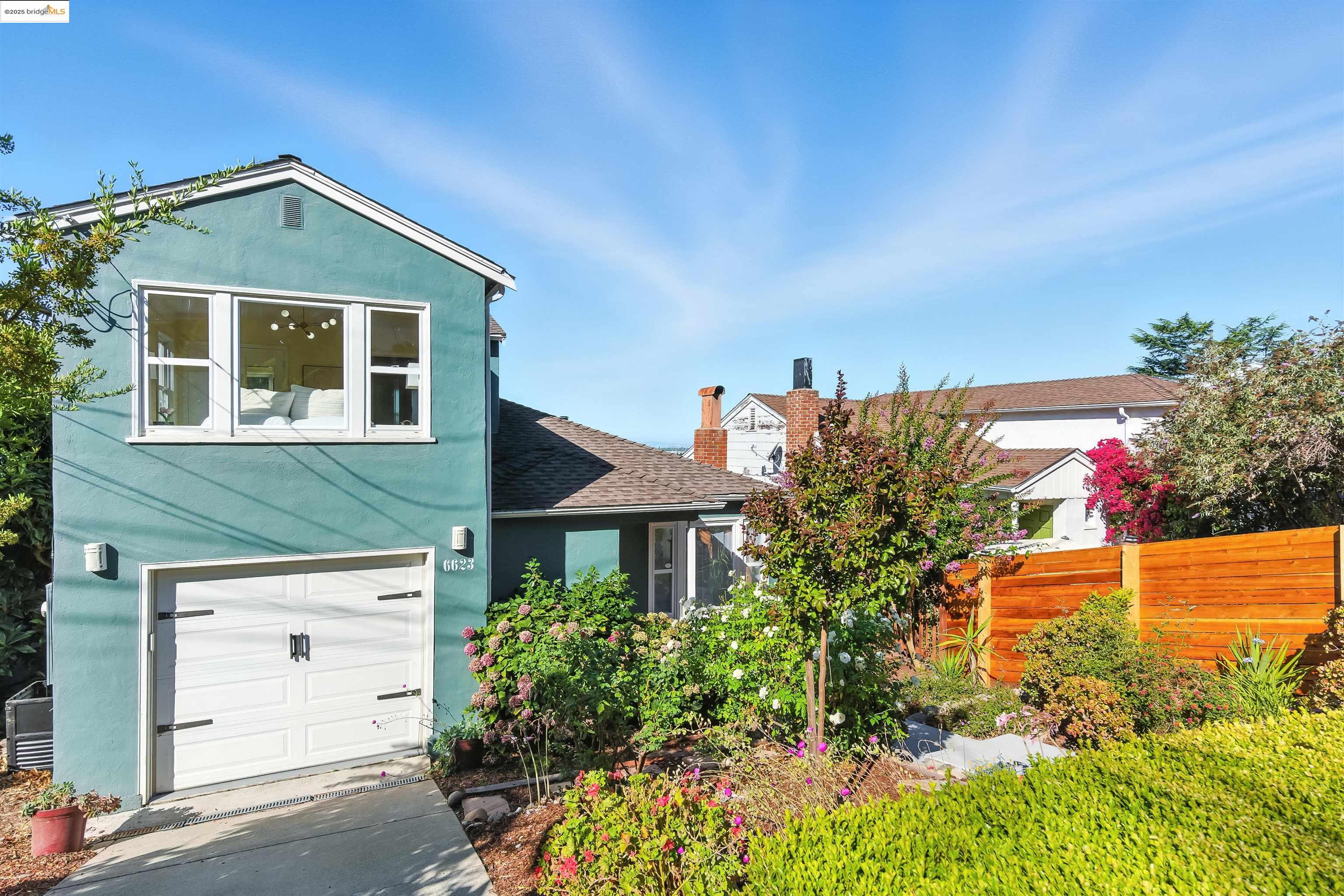 6623 Outlook Avenue Oakland, CA 94605 - Photo 3 of 38 View of front of house featuring stucco siding, an attached garage, roof with shingles, and a chimney