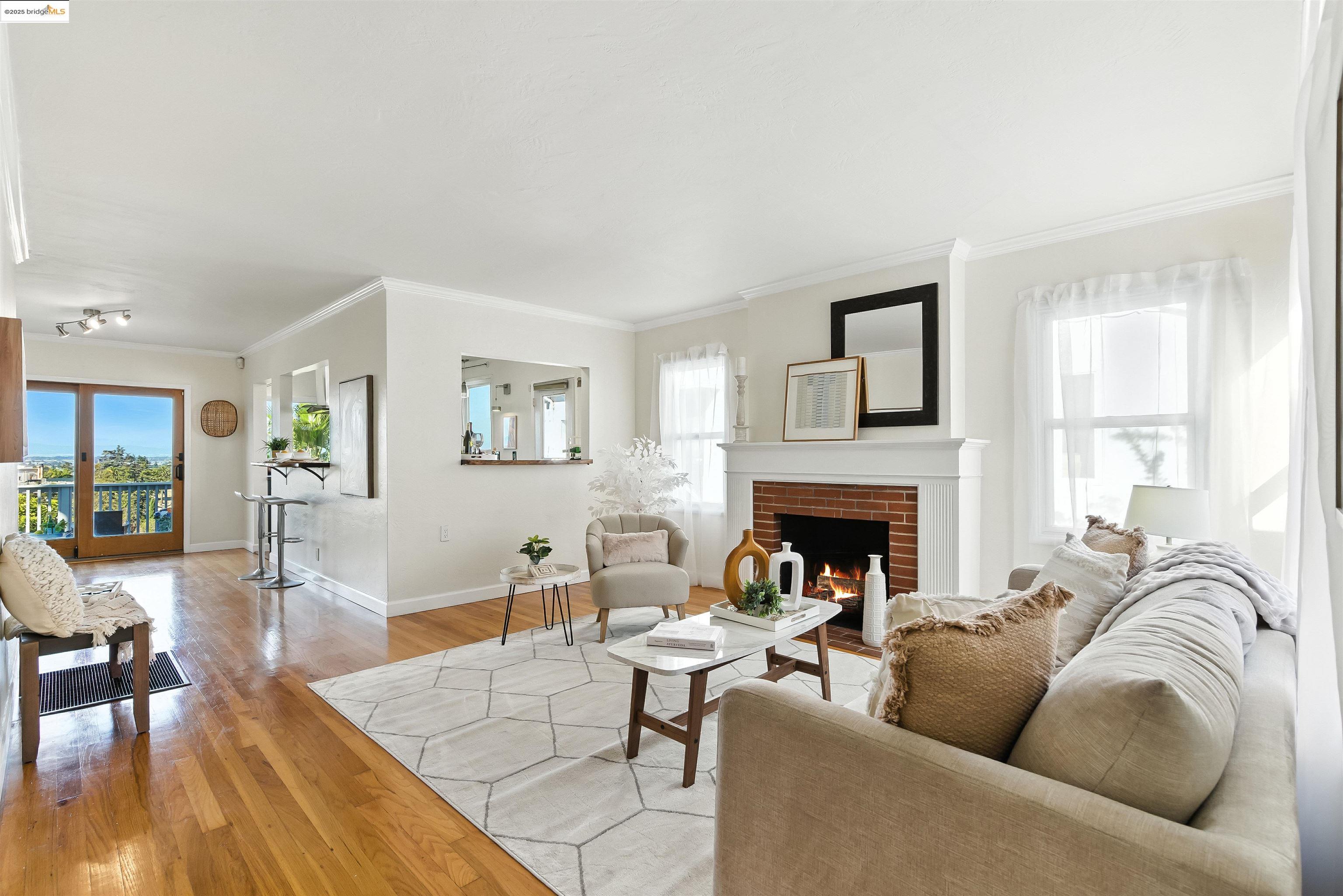 6623 Outlook Avenue Oakland, CA 94605 - Photo 6 of 38 Living area with crown molding, light wood-style flooring, and a brick fireplace