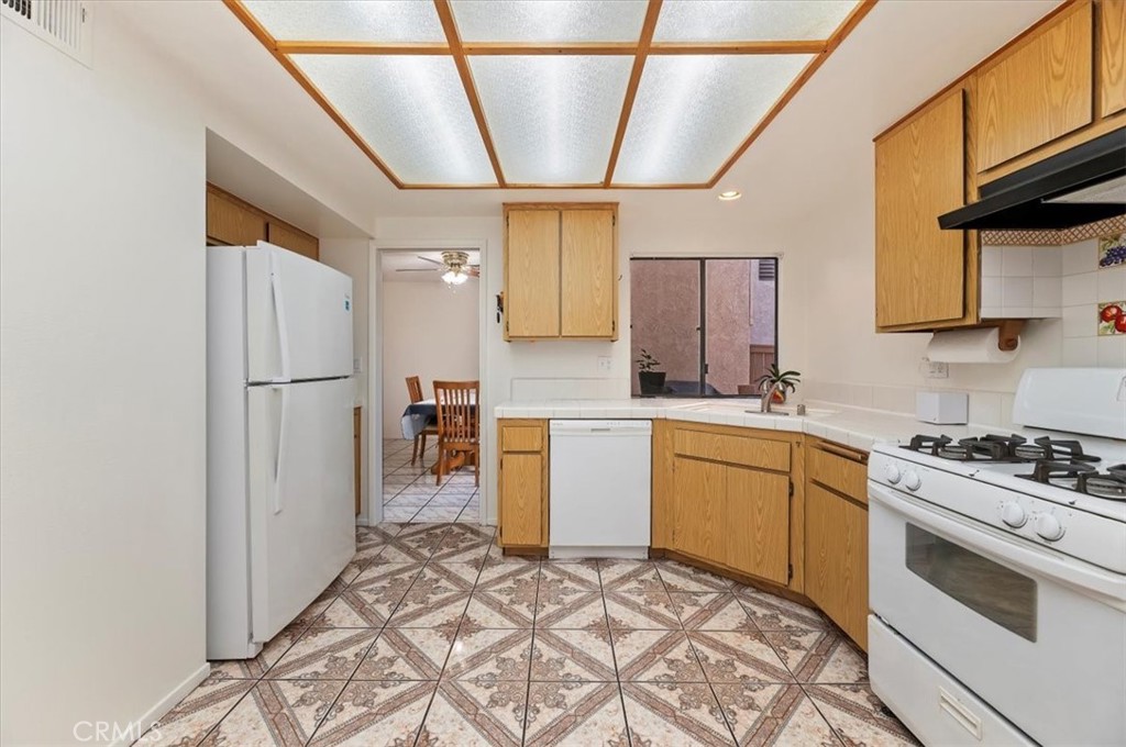 9765 Louise Way Rancho Cucamonga, CA 91730 - Photo 12 of 28 a kitchen with a refrigerator sink stove and cabinets