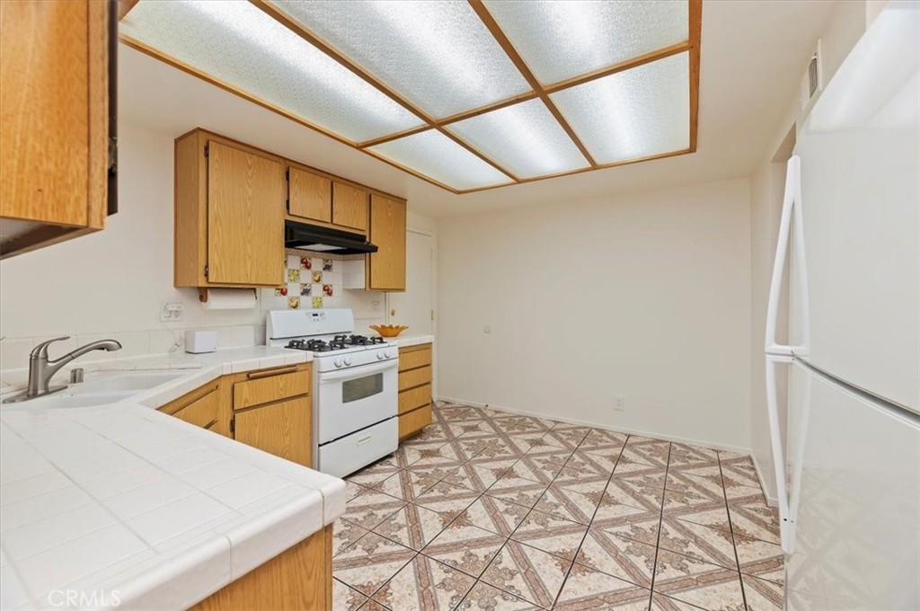 9765 Louise Way Rancho Cucamonga, CA 91730 - Photo 9 of 28 a kitchen with a sink a stove and a refrigerator