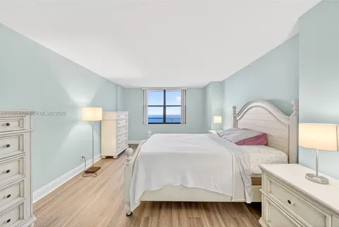 a spacious bedroom with a bed and a dresser