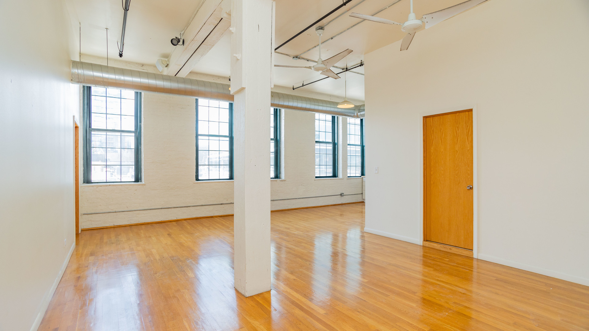 159 North Racine Avenue, Unit 2W Chicago, IL 60607 - Photo 4 of 11 a view of an empty room with wooden floor and a window