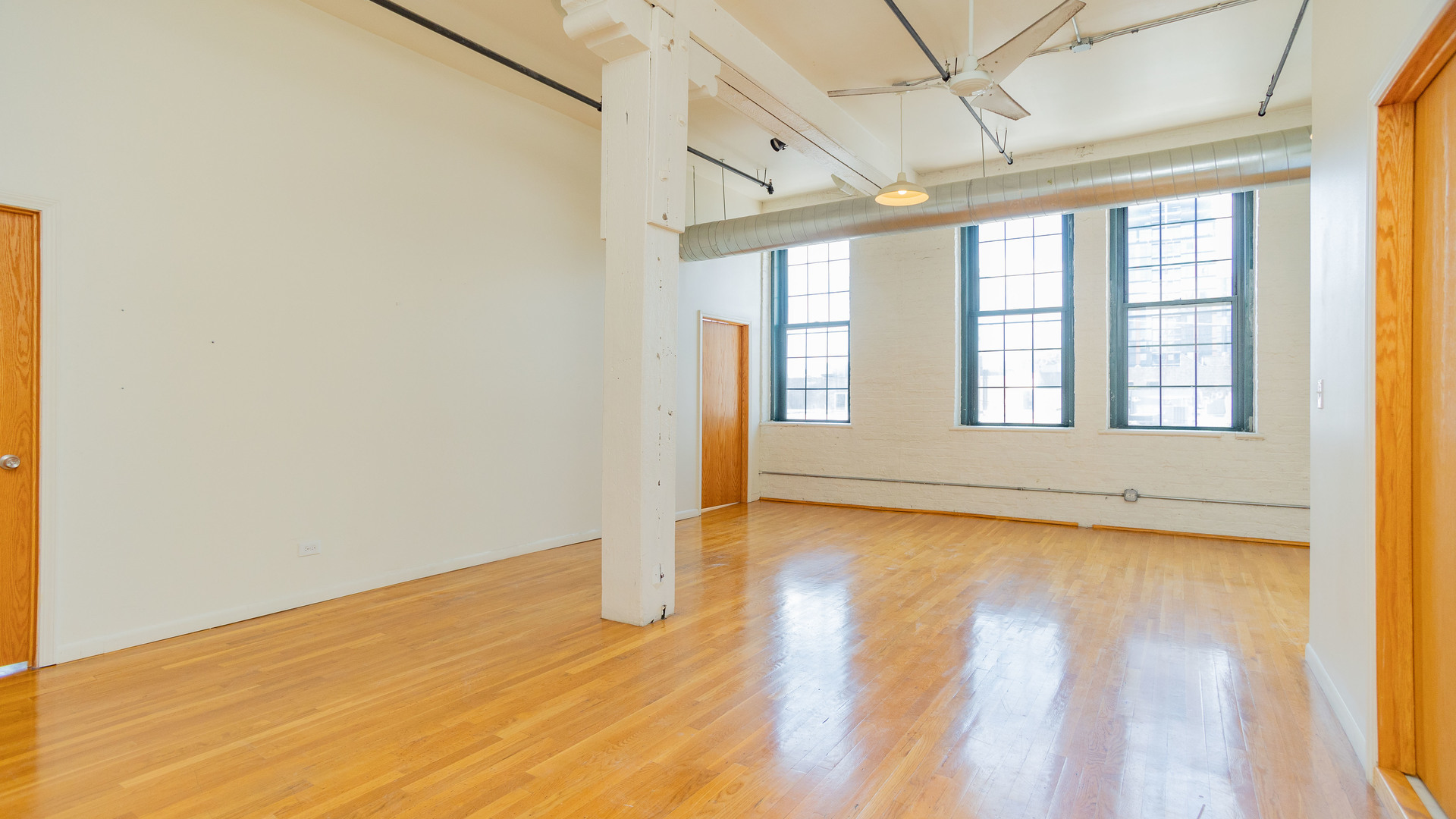 159 North Racine Avenue, Unit 2W Chicago, IL 60607 - Photo 5 of 11 a view of an empty room with a window and wooden floor
