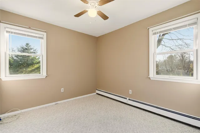 an empty room with a window and a fan